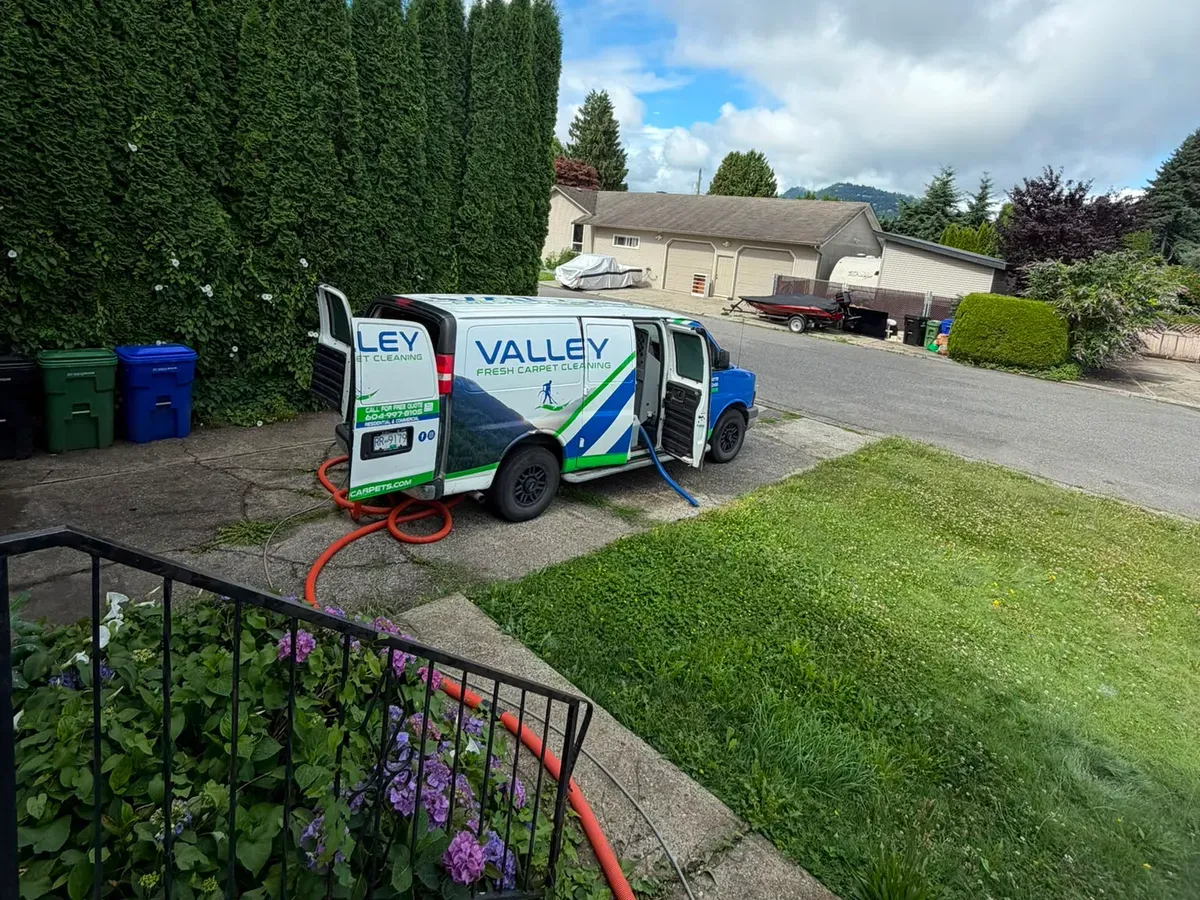 Valley Fresh Carpet Cleaning van with hoses run to the front door of a Sandy Hill family home in Abbotsford