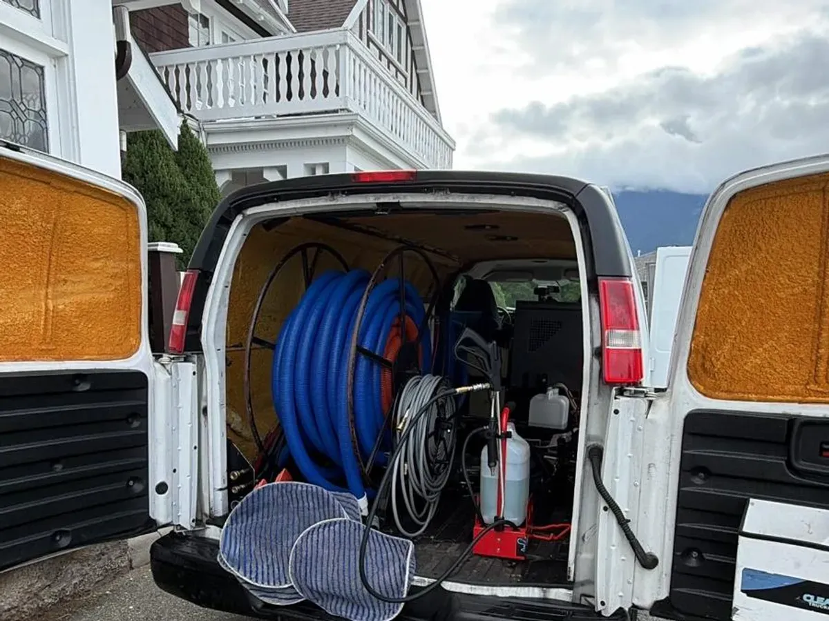 Valley Fresh Carpet Cleaning van with rear doors open outside a heritage home near Fort Langley