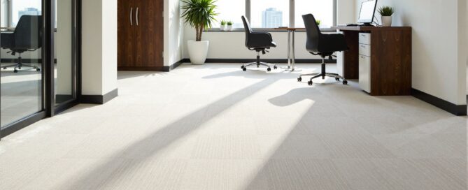 A wide shot of a pristine, well-maintained commercial carpet in a modern office setting.